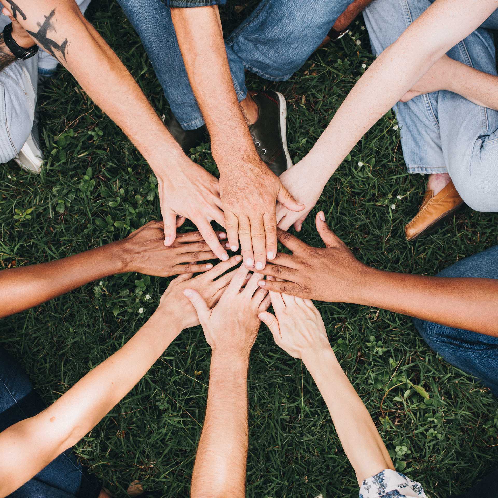 La diversité et l'inclusion : des mains de différentes personnes qui se rejoignent